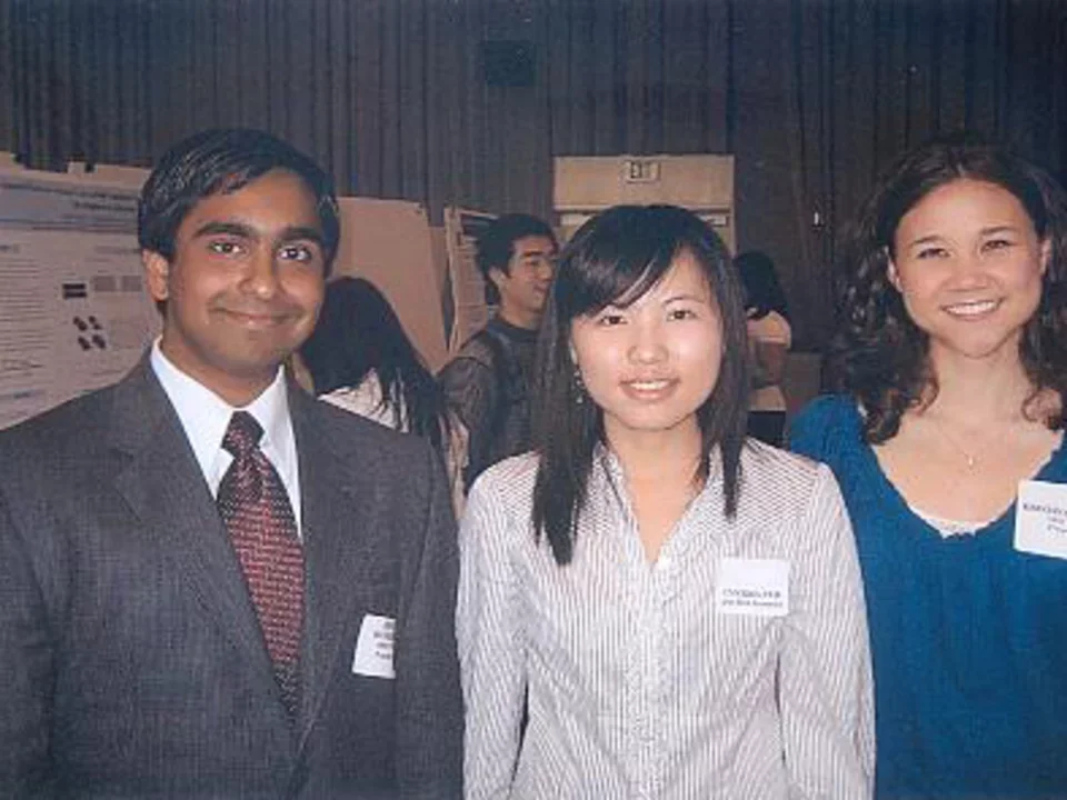 2 woman and man in front of poster presentations
